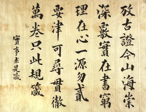 누런 종이에 큰 해서로 세로줄 여러 줄을 쓰고, 왼쪽에 작은 글씨로 「實事求是箴」이라 적은 글씨 작품.